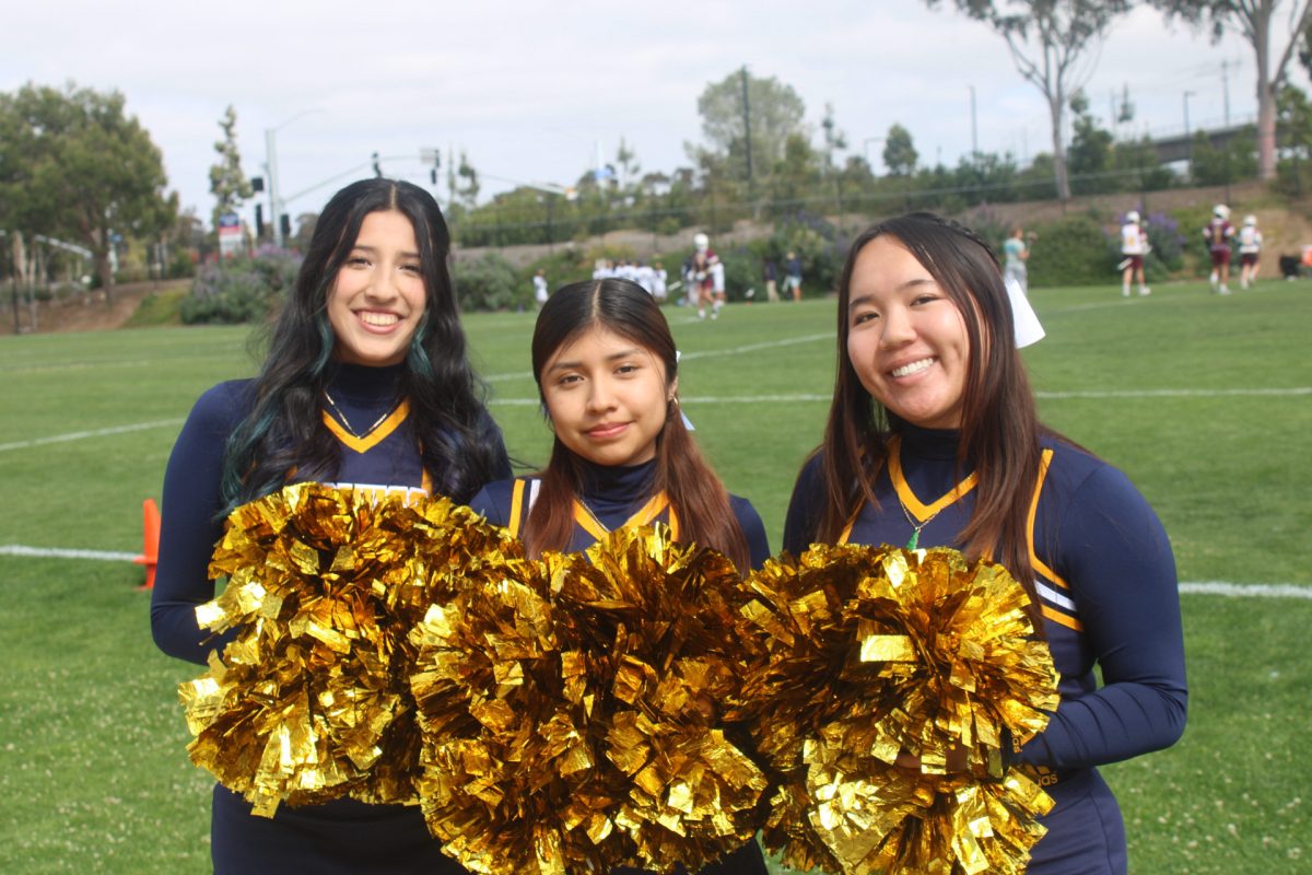 Jacqueline Hernandez (24), Jessica Mariano (24), and Nicole Nguyen (24) are preparing to cheer for a boys lacrosse game. 