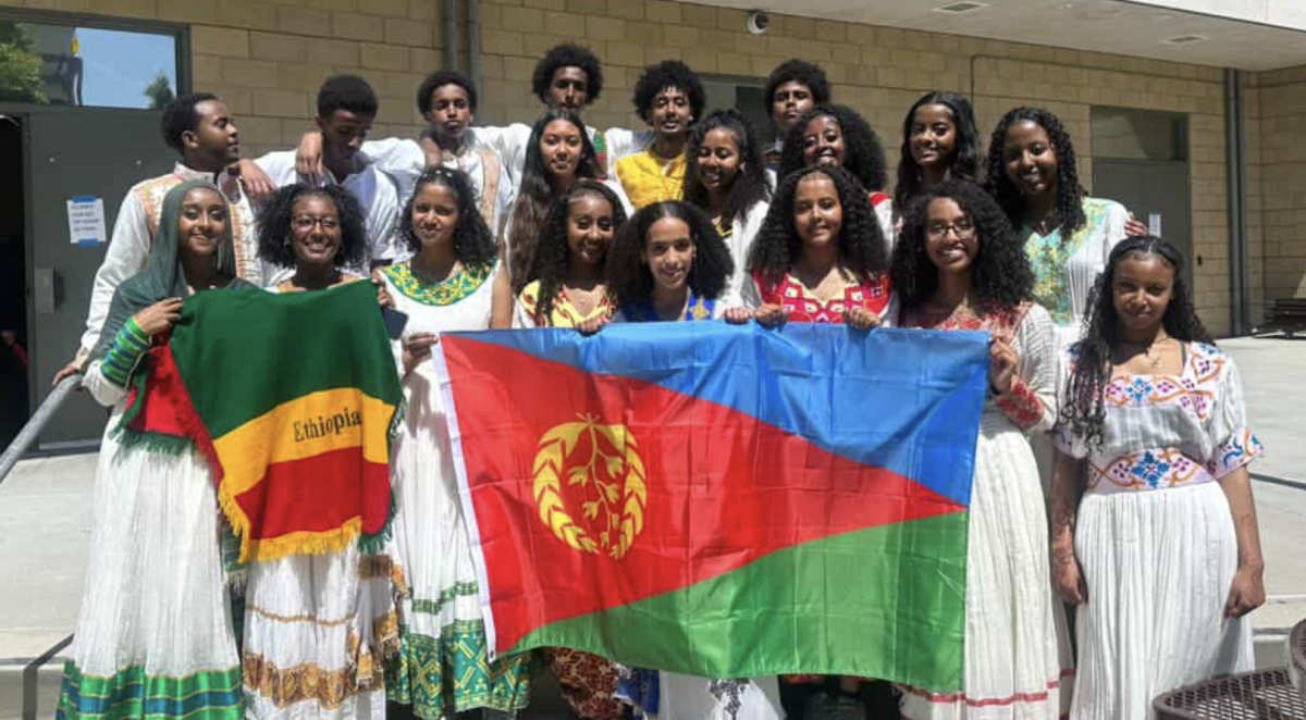 BSU Performers holding up flags that represent their culture. 