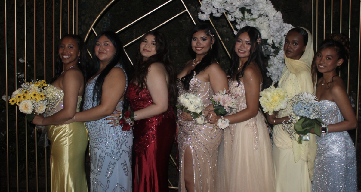 Students posing infront of prop from prom
