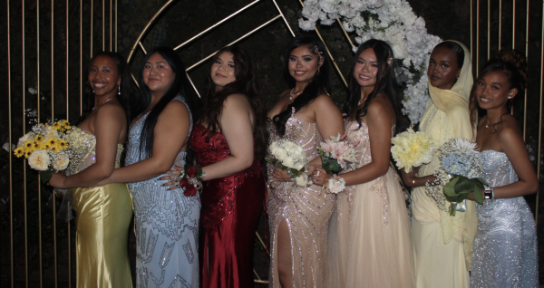 Students posing infront of prop from prom
